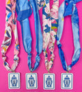 Colorful headbands with floral and geometric patterns on a pink background
